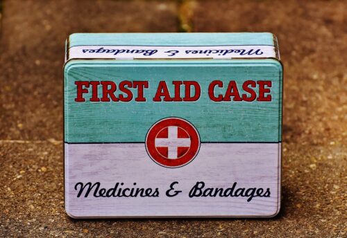 an old tin style first aid box that reads First Aid Case Medicines & Bandages