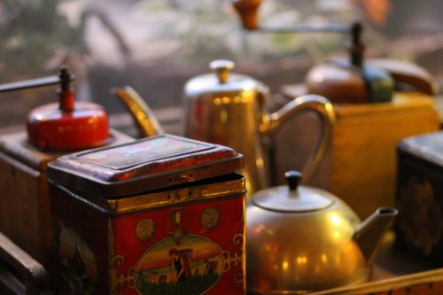 Vintage teapots and tins showcasing the historical roots and traditional blends behind what is in green tea.