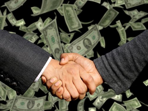Handshake with falling cash in the background, representing financial investment in weight loss industry equals BIG business.