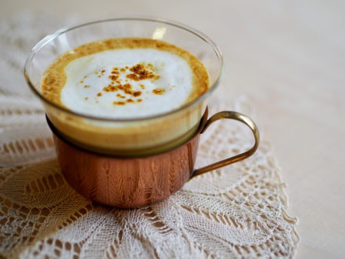 Turmeric Golden Milk served in an elegant copper mug, garnished with ground cinnamon or turmeric for flavor and visual appeal.