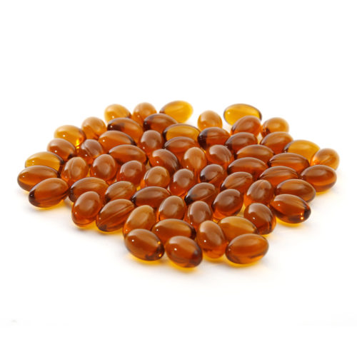 Glossy black seed oil capsules on white background—an easy option for those wondering how to take black seed oil in supplement form.