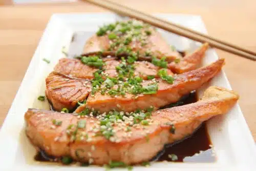 Grilled salmon fillets topped with green onions and sesame seeds—high-protein, omega-rich belly-fat burning food option.