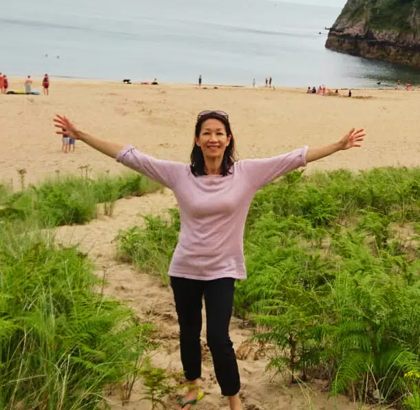 Image of Blending Herbal Tea owner on a beach with outstretched arms